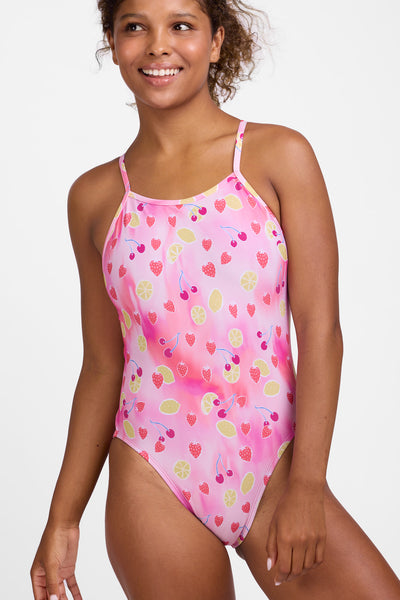 Female model wearing the Women’s Gavin One Piece Swimsuit in the Berry Zest print, standing in front of a grey background, shown from front view. 