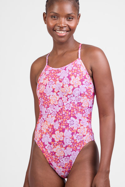 Female model wearing the Women’s Gavin One Piece Swimsuit in the Zinna print, standing in front of a grey background, shown from front view. 