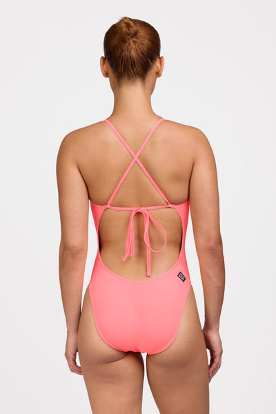 Female model wearing the Women's Jackson One Piece Swimsuit in the Papaya solid, standing in front of a grey background shown from the back view 

|| Size 32, Hip 62.5"  
