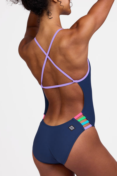 Female model wearing the Women's Julian One Piece Swimsuit in the Navy contrast, standing in front of a grey background shown from the side view

|| Size 28, Torso 56" 