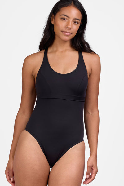Female model wearing the Women's Toni One Piece Swimsuit in the Black solid, standing in front of a grey background shown from the front view

|| Size 30, Height 5'9"