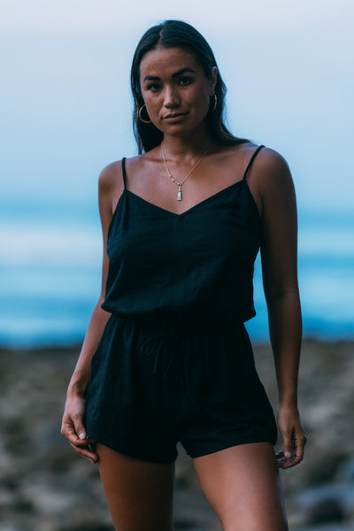 Female model wearing the Women's Naia Romper in the Black solid, standing in front of a blue background shown from the front view

|| Size S, Height 5'4"  