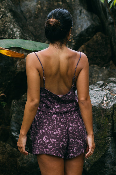 Female model wearing the Women's Naia Cover Up Romper in the Bondi Blossom print, standing in front of a green background shown from the back view

|| Size S, Height 5'4" 