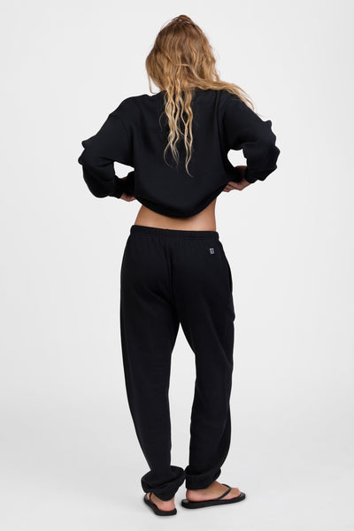 Female model wearing the Women's Melanie Sweat pant in the Black solid, standing in front of a grey background, shown from the back view

|| Size S, Hips 34.5"   