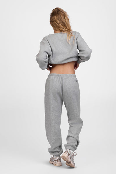 Female model wearing the Women's Melanie Sweat pant in the Heather Grey solid, standing in front of a grey background, shown from the back view

|| Size S, Hips 34.5"  