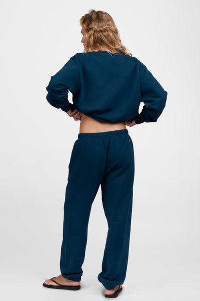 Female model wearing the Women's Melanie Sweat pant in the Indigo solid, standing in front of a grey background, shown from the back view

|| Size M, Hips 34.5"  